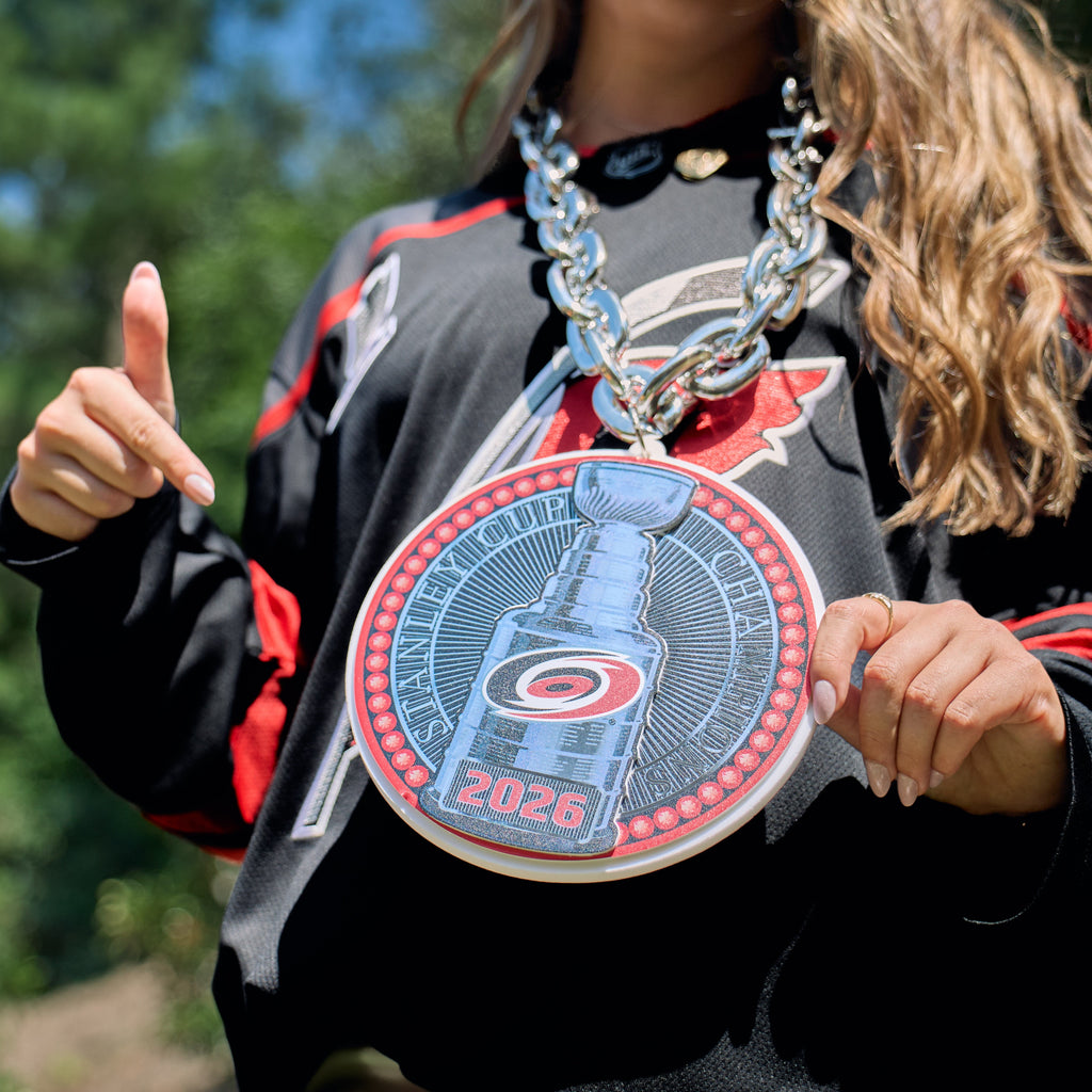 The chain being worn by a model outdoors, pointing at the pendant