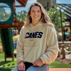 The hoodie being worn by a model outdoors in front of a playground