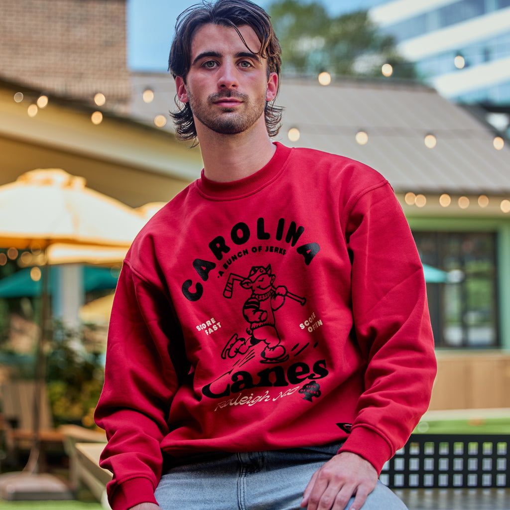 The crewneck being worn by a model in front of a ping pong table