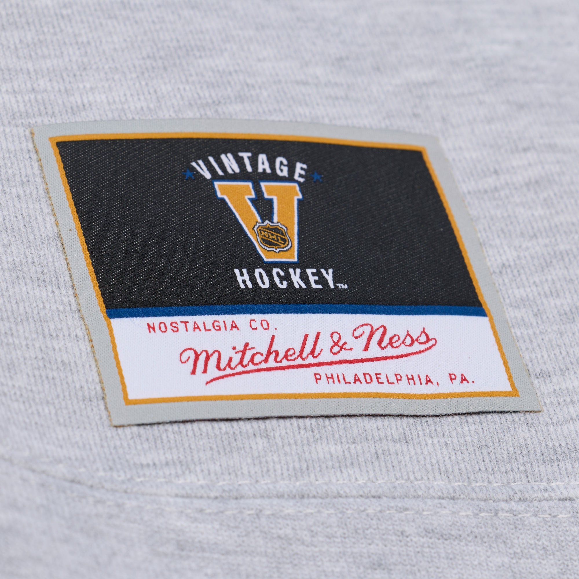 Close up of the Mitchell & Ness Vintage Hockey tag at the front left waist