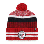 Front: Red cuffed beanie with black/white accents, ovular patch on cuff, red pom