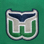 Left: Close up of the Whalers Tail logo on left side of hat