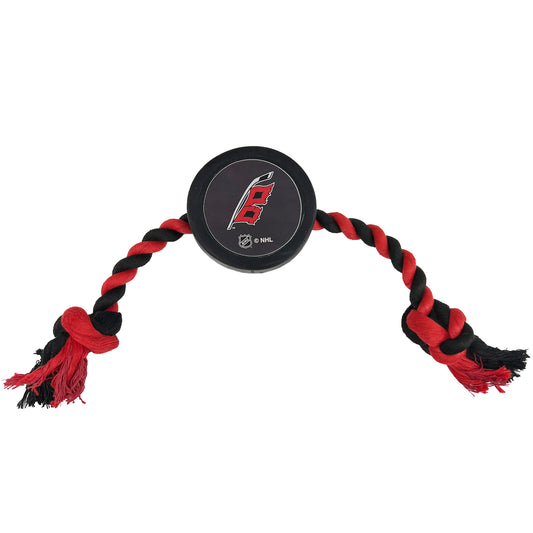 Rubber puck with flags logo and red and black rope attached to sides of puck