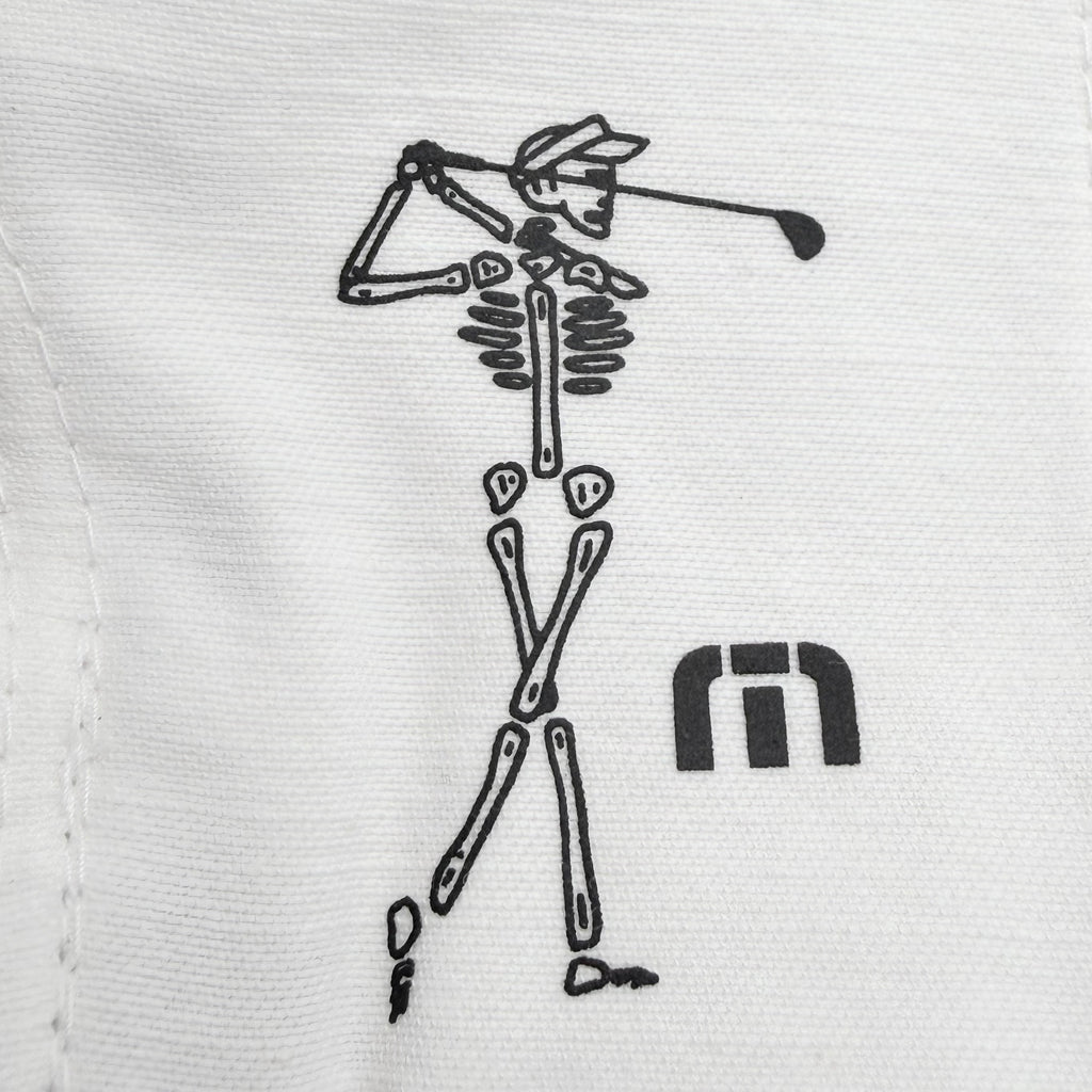 Close up of Travis Mathew art, Skeleton playing golf next to TM logo