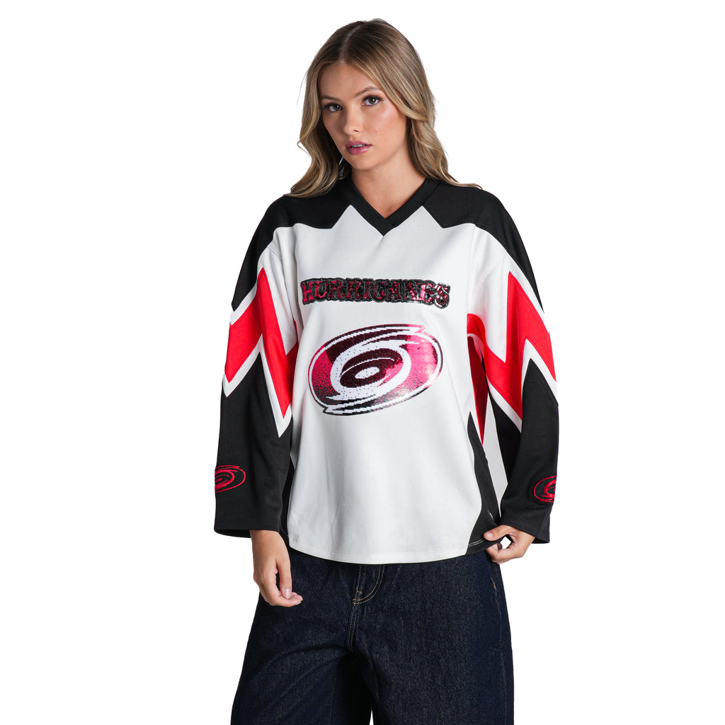 White longsleeve top, red/black accents, "HURRICANES" and Primary logo on front in red sequin