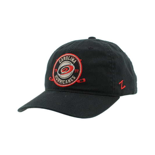 Side: Black hat with circular patch graphic on front, red Zephyr logo on left