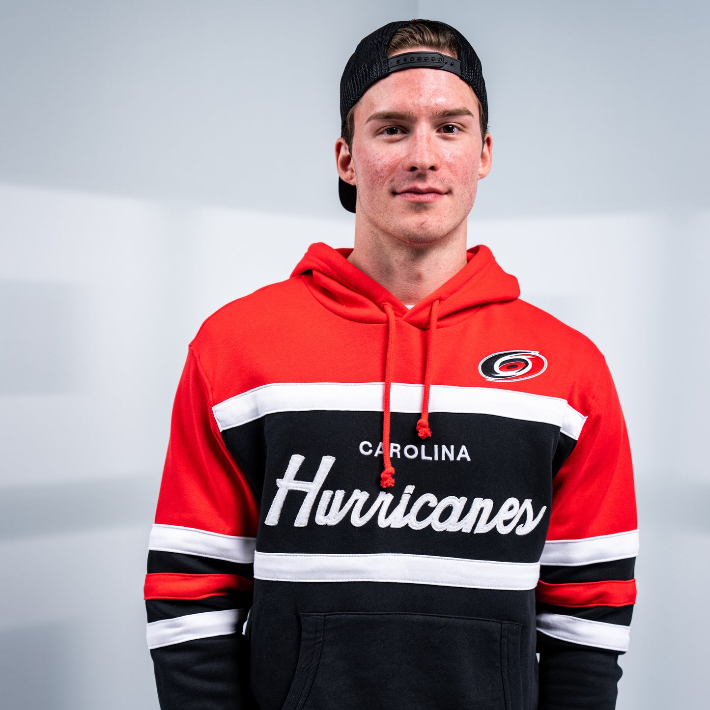 Hurricanes forward Andrei Svechnikov posing while wearing the hoodie