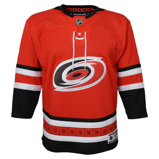 Front: red jersey with black and white trim, flag striping, Primary logo on front