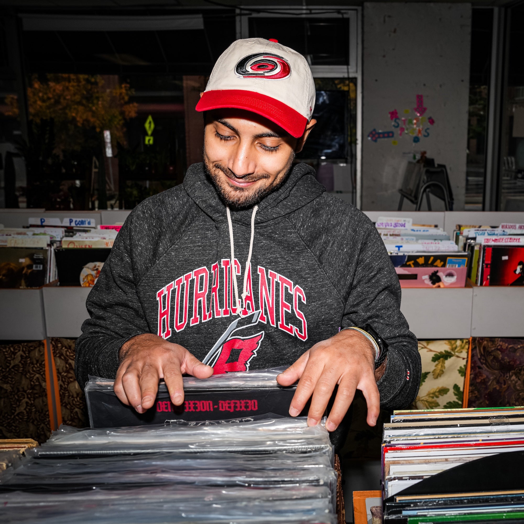 A model wearing the hat while inside a record store