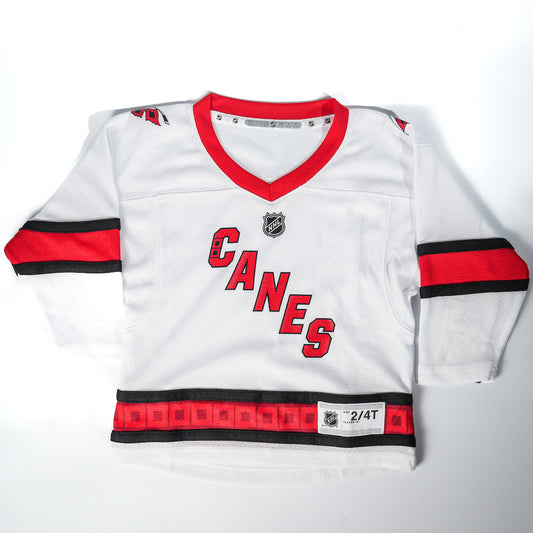 White jersey with red and black trim, Canes diagonal logo across chest