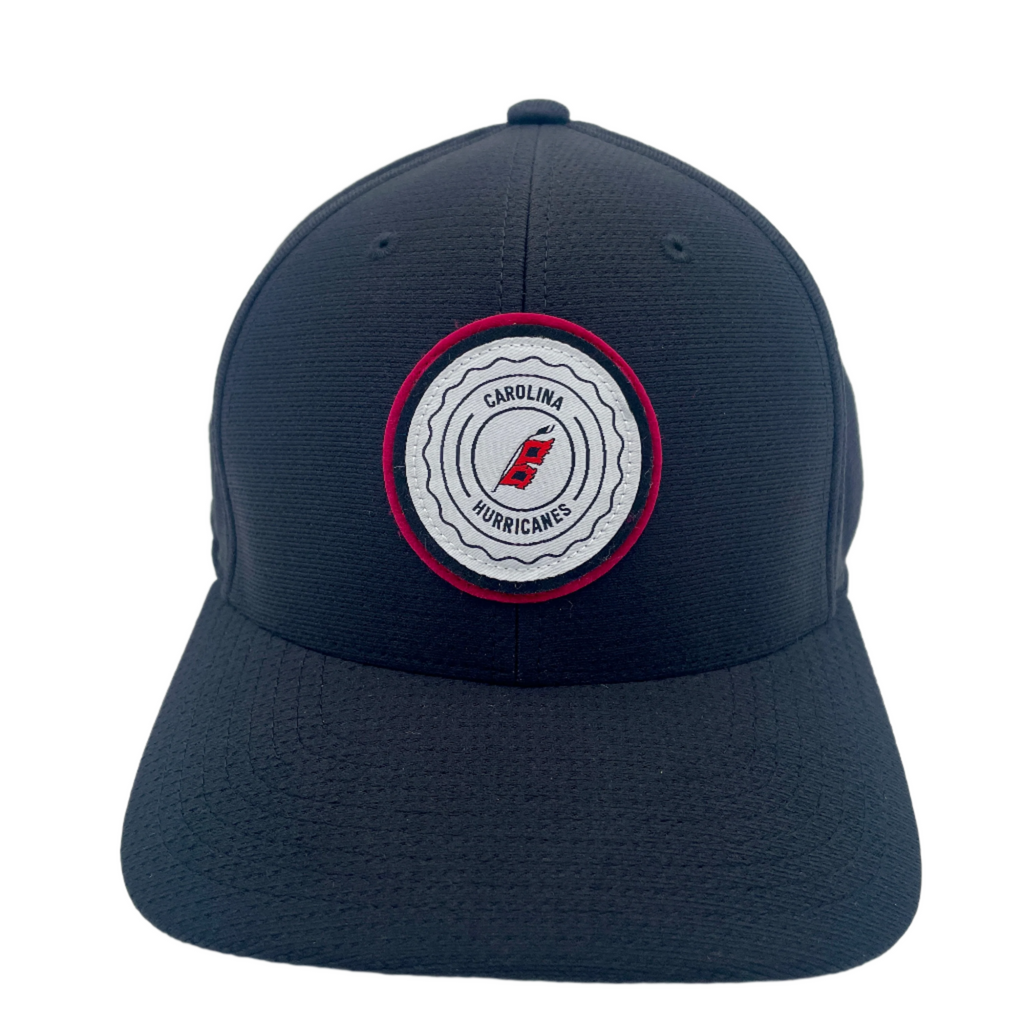Front: Black hat with white and red circular patch, says Carolina Hurricanes with Flags logo
