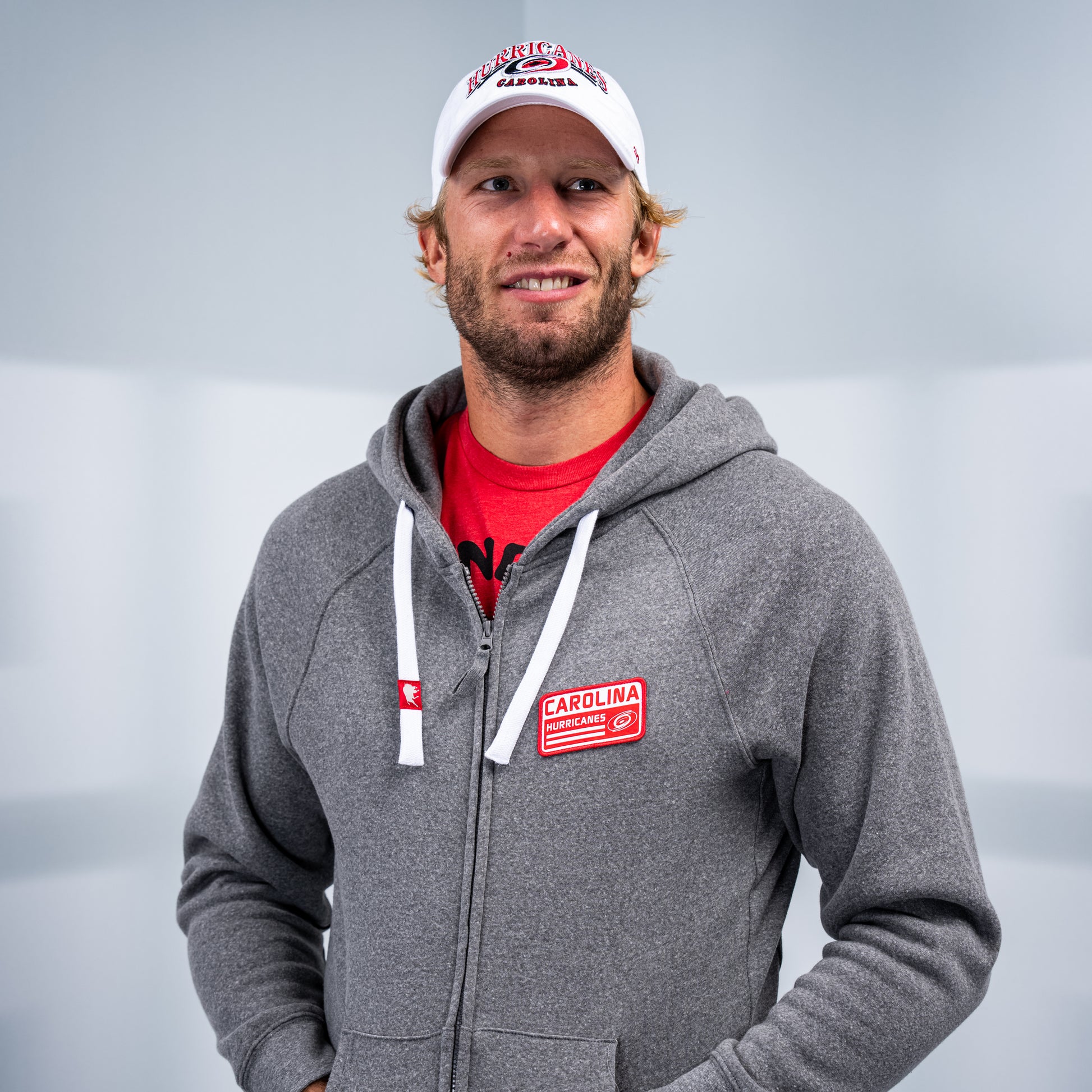 Hurricanes forward and Captain Jordan Staal posing while wearing the hoodie