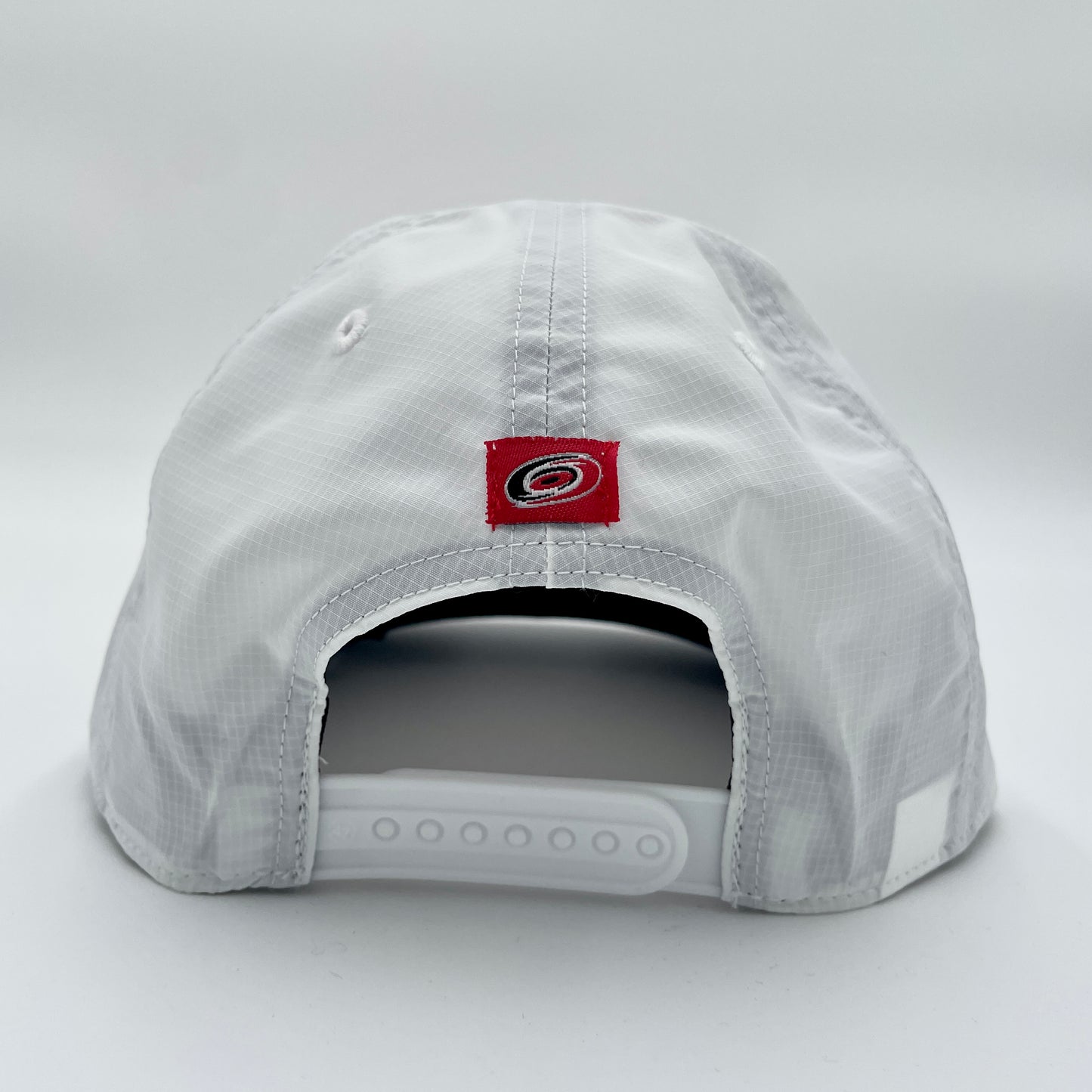 Back: White hat with white snapback straps, Red tag with Primary logo above straps