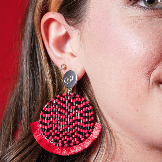 47mm Hand-beaded circle with alternating black and red beads with soft felt backing, fringe lining bottom, attached to logo stamped charm