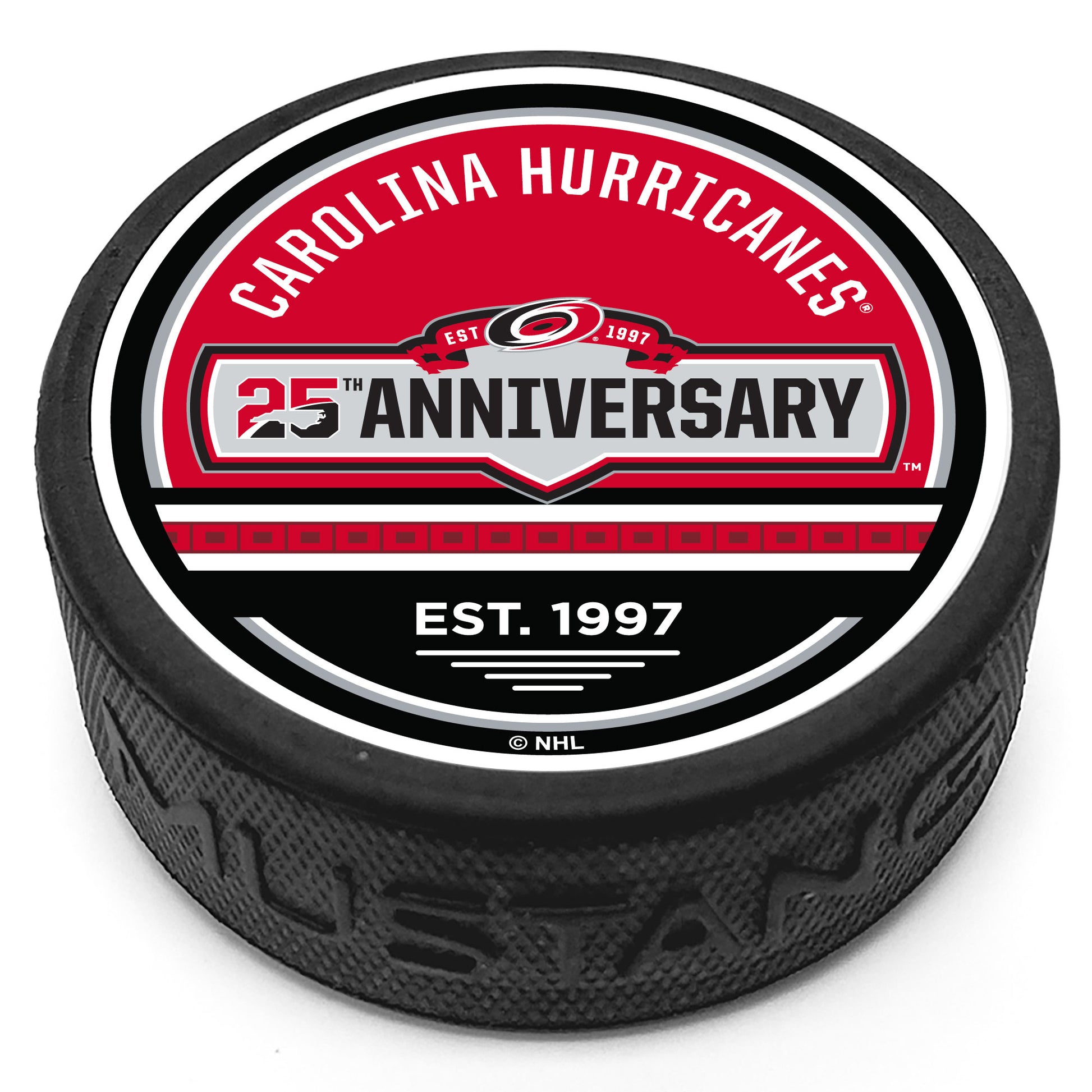 Hockey puck with the Hurricanes 25th Anniversary jersey patch logo in the center with "Carolina Hurricanes" above and our signature flag stripe with the phrase "Est. 1997" below on a red and black top face.