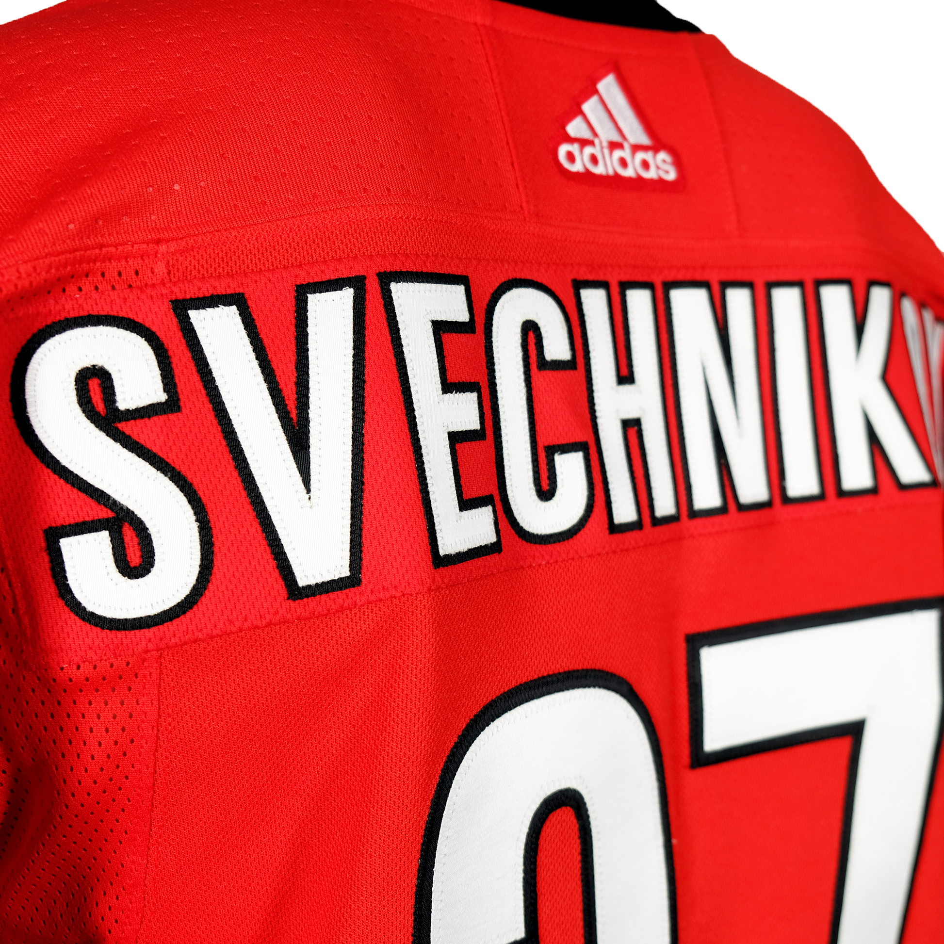 Close up of stitching of nameplate that reads "Svechnikov"