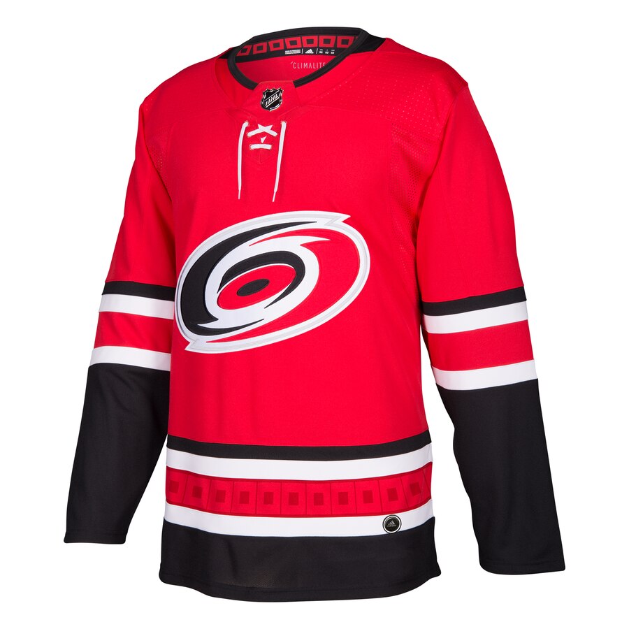 Front View: Red jersey with black/white stripes and Hurricanes primary logo.
